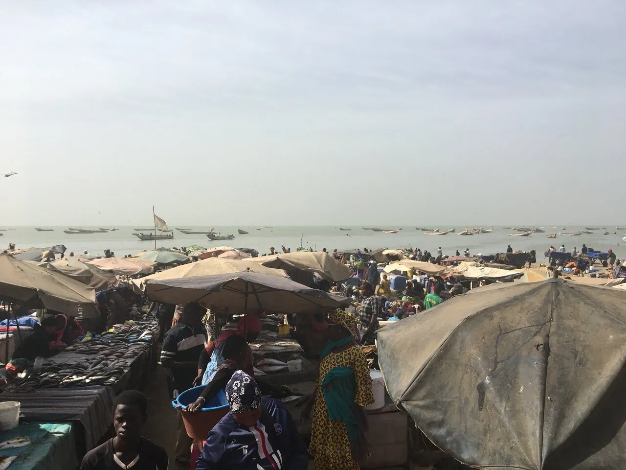 Fischmarkt am Strand von Mbour, Pirogen im Wasser